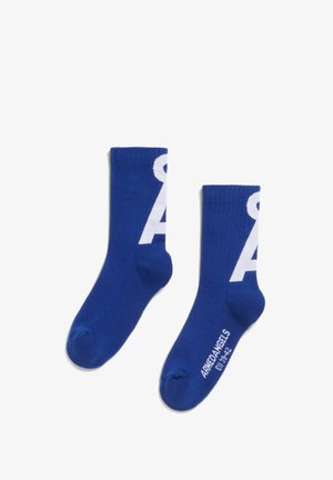 Une paire de chaussettes bleu marine avec un design de lettre "A" blanche et le texte "ARMEDANGELS EU 39-42" sur la semelle, posées à plat sur un fond blanc.