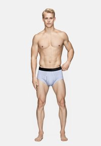 Lyseblå bomuldsunderbukser med en sort elastisk talje. Designet har en frontpouch og en tætsiddende pasform, der fremhæver en glat tekstur.