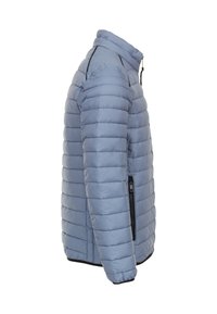 Világoskék puffertakaró, vízszintes steppeléssel, magas gallérral, cipzáras oldalzsebbel és elasztikus mandzsettával a meleg és a tökéletes illeszkedés érdekében.