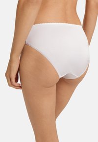 Vita högmidjade trosor gjorda av en slät tyg, med en scalloped detaljer vid midjan och sömlösa sidor för en ren look.