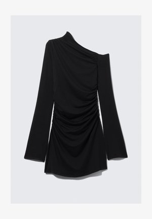 Juodas ilgomis rankovėmis viršus su vieno peties dizainu, pabrėžtas raukšlėto audinio ir lygaus paviršiaus, kirpimas ties juosmeniu su platėjančiomis rankovėmis.