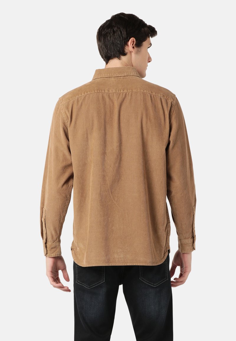 Camisa de pana marrón con mangas largas, puños abotonados y cuello clásico, que presenta una superficie texturizada y un corte relajado.