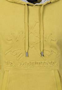Gul hoodie med grå inredning, prydd med präglade häst- och ryttardesigner, en framficka och huva med snörning. "La Martina"-logotypen visas.