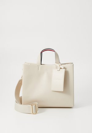 Beež nahktootakott kahekordsete ülemiste käepidemetega, eemaldatava rihma ja pagasimärgiga. Omab lukuga sulgemist ja peent reljeefset logo.