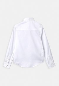 Vit långärmad skjorta med rak fåll, knappmanschetter, spetsig krage och slät tygstruktur. Endast bakvy.