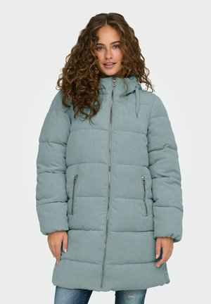 Manteau rembourré en tissu côtelé doux de couleur sarcelle avec une fermeture éclair à l'avant, une capuche avec cordon de serrage et deux poches latérales zippées. Manches longues avec poignets élastiques.