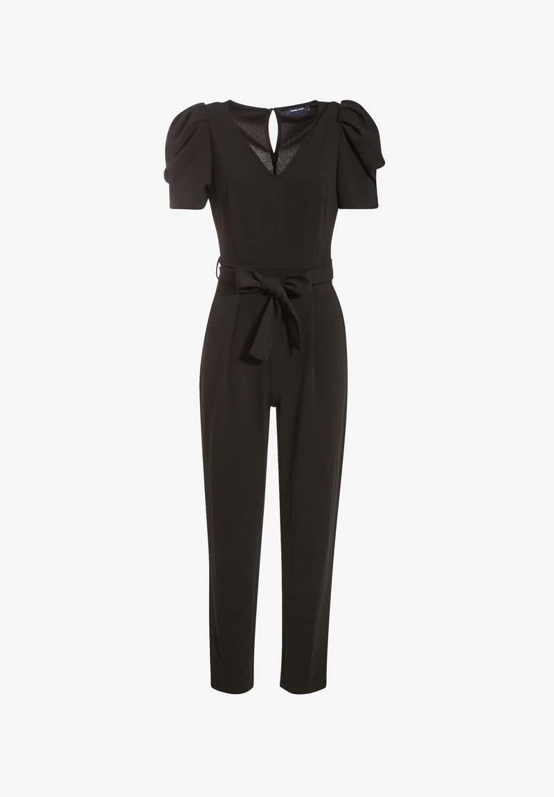 Combinaison noire avec manches courtes bouffantes, encolure en V ajourée, jambes fuselées et ceinture en tissu nouée à la taille.