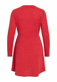 Robe rouge côtelée à manches longues, encolure ronde, corsage ajusté et jupe évasée. Tissu texturé avec un motif subtil.