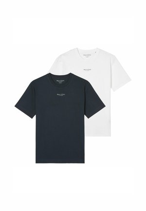 Hombre vistiendo una camiseta blanca lisa de manga corta con un pequeño logo "Marc O'Polo" en el pecho, combinada con pantalones beige, manos relajadas a los lados.