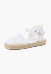 Weiße Espadrille-Sandale mit gewebtem Canvas-Obermaterial, gewelltem Design, Knöchelriemen mit silberner Schnalle und Juteschnur-Sohle.