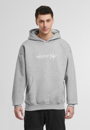 Grauer Kapuzenpullover mit einer Fronttasche, mit einem weißen Textdruck "Home Boy" in einer lässigen Schriftart. Weicher, strukturierter Stoff mit gerippten Bündchen.