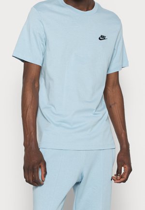 T-shirt Nike bleu clair à manches courtes en coton doux. Présente un petit logo noir sur le côté gauche supérieur de la poitrine et un col rond classique.
