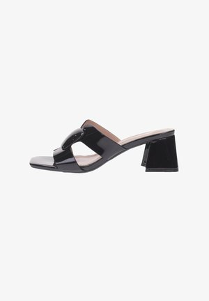 Mule en cuir verni noir à bout ouvert avec talon bloc, large bride avant ornée d'une grande boucle circulaire.