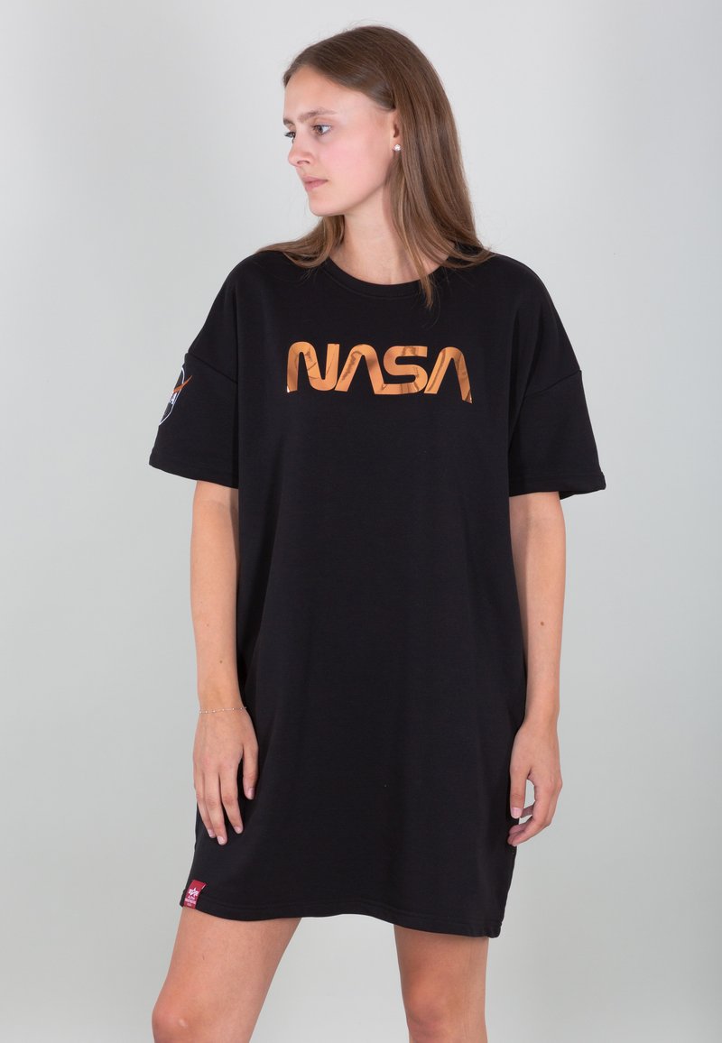 Crna oversized haljina majica s bakrenim "NASA" logotipom sprijeda. Kratki rukavi i crvena oznaka s logotipom na rubu. Mekani pamučni materijal.