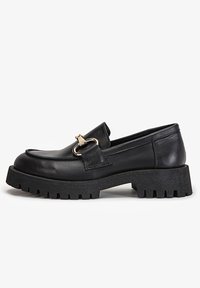 Czarne skórzane loafersy z okrągłym noskiem, złotymi akcentami oraz grubą, teksturowaną czarną podeszwą o szorstkim wzorze.