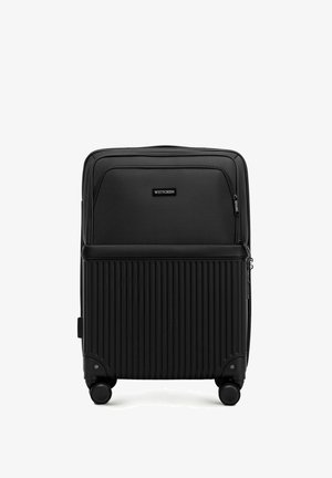 Valigia nera con ruote, dotata di un design testurizzato a righe. Presenta una tasca frontale con zip e un manico superiore liscio. Compatta e leggera.