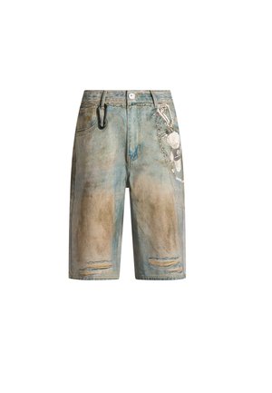 Shorts in denim con toppe logore, accessorio a catena sul lato destro e un moschettone nero agganciato al passante sinistro della cintura.