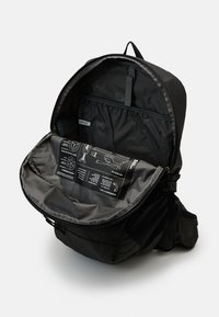 Schwarzer Rucksack mit glatter Oberfläche, einem Hauptfach mit Reißverschluss und einem gefütterten Innenraum, der Organisationsfächer und Anweisungen enthält.