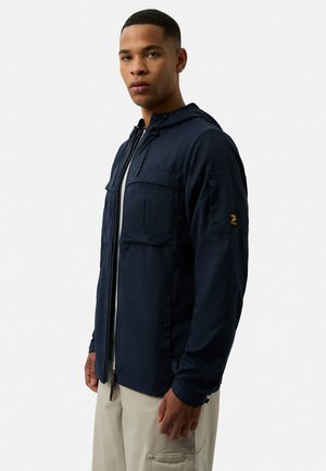 Navy blue lightweight jacket featuring a zip front, drawstring hood, two chest pockets, and a logo accent on the left sleeve.