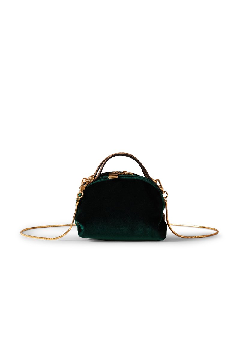 Sac à main en velours vert avec une forme arrondie, des accessoires en or et une anse chaîne détachable. Il comprend une petite poignée supérieure et une texture lisse.