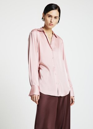 Light pink satin shirt with a pointed collar, long sleeves, and button-down front. Features a relaxed fit and subtle sheen.