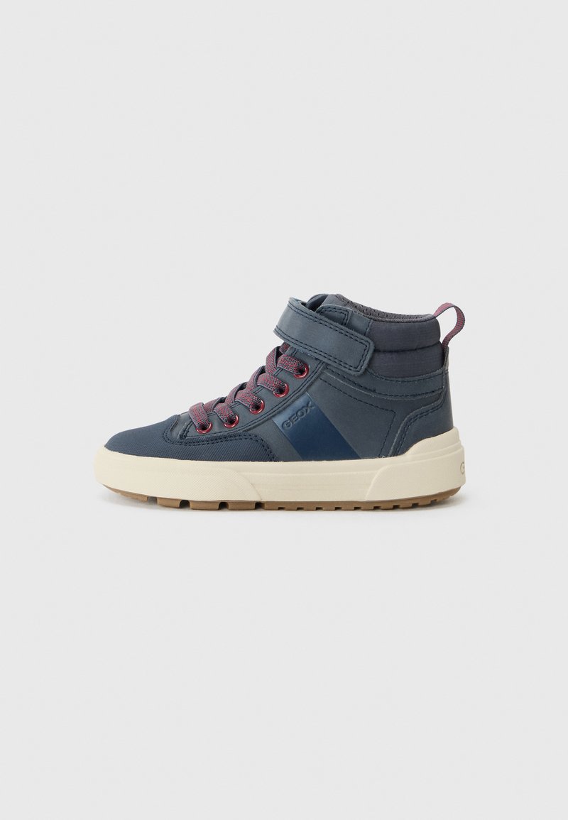 Høye sneakers i marineblå syntetisk materiale med røde snørebånd, en borrelåsrem og en kremfarget gummisåle. Har polstret krage og detaljer.