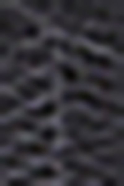 Surface noire texturée avec un motif ondulé, présentant une finition mate. Le matériau semble flexible et légèrement en relief.
