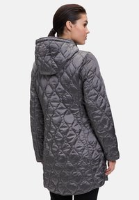 Grijze gewatteerde jas met een capuchon, voorzien van een gedetailleerd ruitpatroon en een langere snit, gemaakt van een glanzend, glad materiaal.