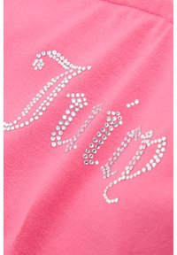 Pink cotton t-shirt featuring a rhinestone-embellished design with decorative lettering. Smooth texture, short sleeves, and relaxed fit.