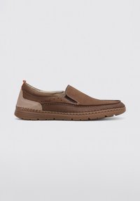 Zapato marrón de tipo slip-on con parte superior de ante suave y cuero texturizado. Presenta acentos en beige contrastantes y una suela de goma flexible.
