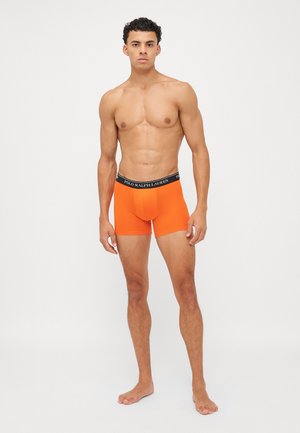 Boxeri portocalii din material fin cu un elastic negru pe talie, pe care este inscripționat textul "POLO RALPH LAUREN". Material neted, design ajustat și lungime medie până la coapsă.