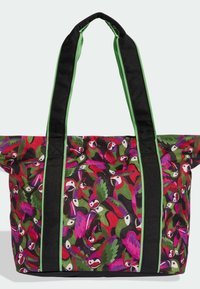 Bolsa tote con asas negras y verdes, presenta un patrón colorido de loros rojos, morados y verdes sobre un fondo negro.