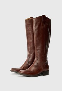 Brown leather knee-high boots with a flat heel, featuring a subtle decorative seam along the sides, set against a plain white background.