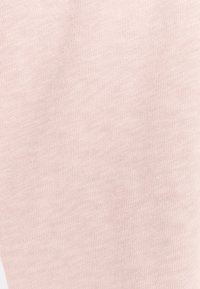 Ljusrosa tyg med en fin, slät textur, med ett konsekvent stickat mönster. Inga synliga detaljer eller extra delar.