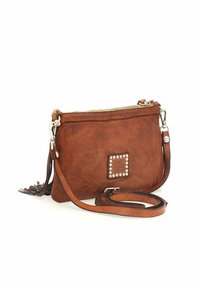 Borsa a tracolla in pelle marrone con chiusura a zip, decorazioni quadrate con borchie, tracolla removibile e un pompon decorativo sul lato.