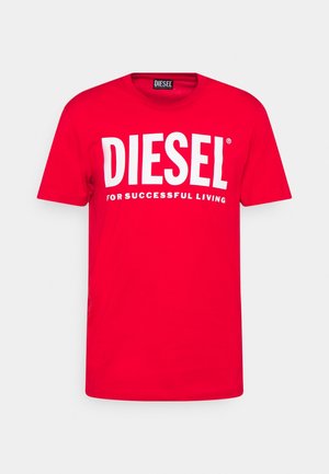 T-shirt en coton rouge avec un logo "DIESEL" blanc et le slogan "POUR UNE VIE RÉUSSIE" en caractères gras. Design classique avec col rond.
