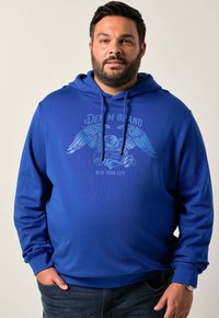 Sudadera azul hecha de material suave con un diseño gráfico en el frente que presenta un águila y texto. Bolsillo tipo canguro y capucha con cordón ajustable.