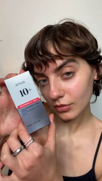 Siero Anua 10+ in una scatola rettangolare argento con testo rosso e nero. Contiene 30 ml, evidenziando gli ingredienti niacinamide e TXA.