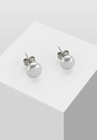Silberne Steckerohrringe mit runden, glatten, weißen Perlen mit glänzender Oberfläche. Einfaches Design und sichere Postfixierung.