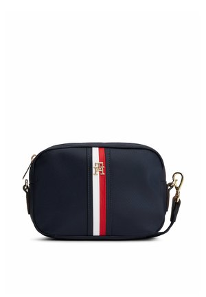 Marineblauwe rechthoekige crossbodytas met centrale rode en witte verticale strepen en een gouden "TH" logo, voorzien van een afneembare riem met gouden gesp.