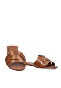 Sandalias de cuero marrón con diseño de tiras cruzadas, punta abierta, suela plana y acabado mate. Sin adornos ni patrones adicionales.
