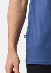 Blå kortärmad skjorta med en mjuk textur. Har en svensk flagga som accent vid sidan och en klassisk passform.