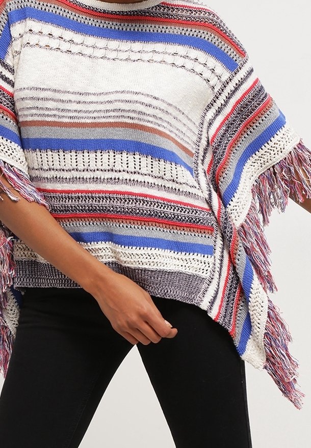 Poncho lavorato a maglia multicolore con strisce orizzontali in rosso, blu e bianco, con bordi frangiati e una vestibilità ampia.