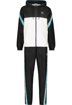 Tuta black and white con cappuccio. Presenta dettagli azzurri e una cerniera. Materiale liscio e lucido con polsini elastici sui polsi e alle caviglie.