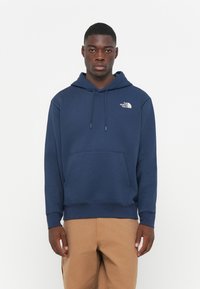 Navyblauwe hoodie van een katoenmix, met een kangoeroezak, verstelbare trekkoordcapuchon en een klein wit logo op de borst.