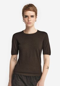 Brun kortærmet strik t-shirt med rund halsudskæring og oprullede ærmer, der har en glat tekstur og tætsiddende design.