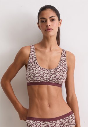Blumenmuster-Bralette in Burgunderrot und Creme, aus weichem Stoff gefertigt. Es hat einen runden Ausschnitt und breite Träger mit einem elastischen Band mit Markenlogo.