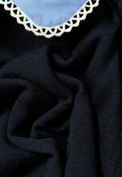 Tejido de punto azul marino con una textura suave, adornado con un cuello azul claro decorado con un ribete de encaje blanco. Se pueden ver arrugas y pliegues.