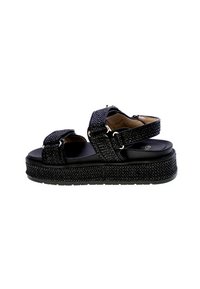 Sandali platform neri con cinturini testurizzati, fasce regolabili per la caviglia e le dita, punta arrotondata e una suola spessa e decorata.
