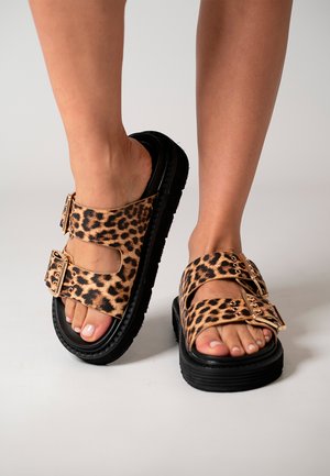 Sandalias de estampado de leopardo con dos correas ajustables, suelas de goma negras y una textura suave. Diseño de punta abierta con uñas de los pies visibles.